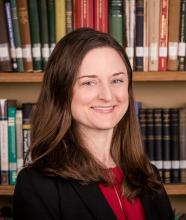Person seated in front of bookshelves