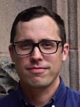 head shot of person with short hair and glasses
