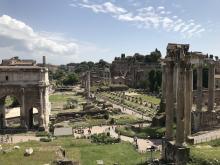 Monuments made out of marble, with columnar facades, dot a flat green landscape
