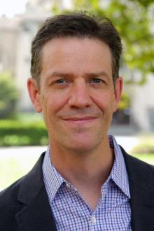 Head shot of person in button-down shirt with blazer