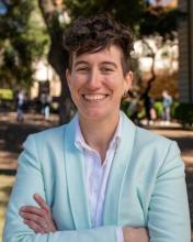Person with short hair and light mint blazer in the woods