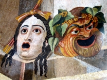 Mosaic of a white comic mask of a woman with mouth open in alarm and a comic mask of a satyr crowned with grapes and ivy. 