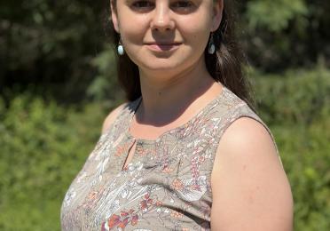 Photo of a white woman with brown hair wearing a green shirt