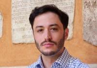 Person in front of wall with inscriptions set into it