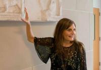 Person pointing to a sculpted relief in a museum
