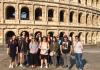 Students pose in front of the Roman colosseum